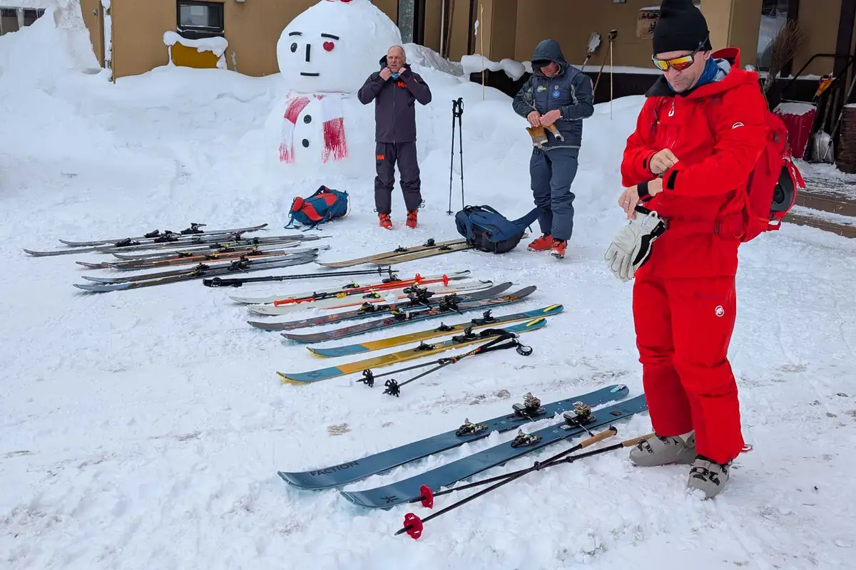 International guests laying out skis and packs in front of Kyounso before a tour