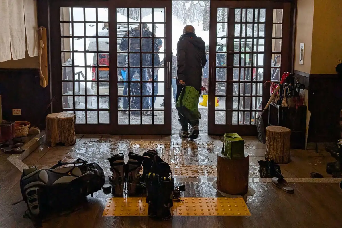 Ski boots and touring packs lined up in the inn's entrance hall